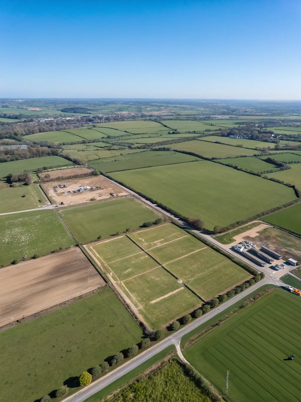 A vast, undeveloped land parcel with lush greenery and clear skies, representing the long-term growth potential of land investments by Charran Charter LLC.